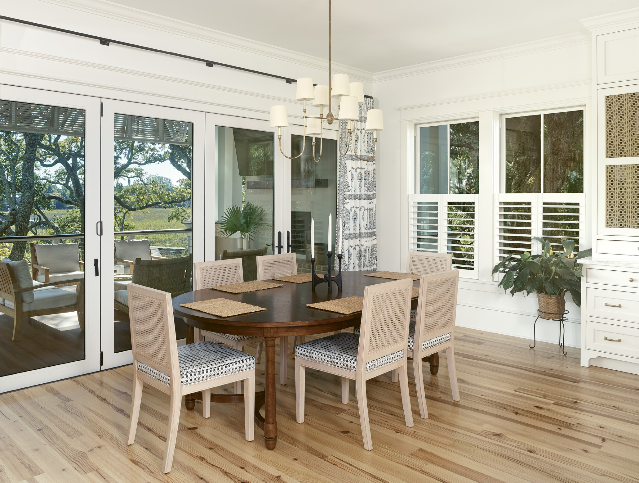 The cozy open dining room features panoramic views of Shem Creek and the property’s ancient live oaks.
